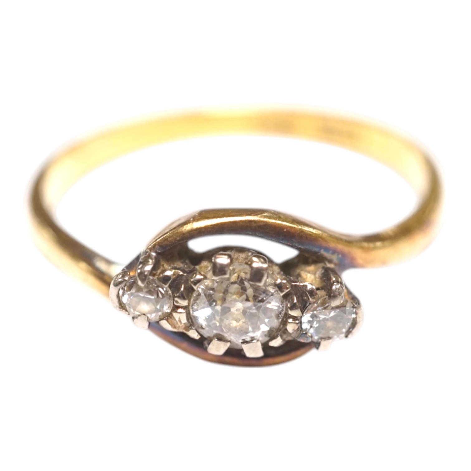 An 18ct, plat and three stone diamond set crossover ring, size Q/R, gross weight 3 grams. Condition - fair